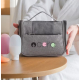 Trousse de toilette grise avec marquage visible sur la poche avant tenue dans les mains d'une femme. Trousse de toilette grise avec marquage visible sur la poche avant tenue dans les mains d'une femme.