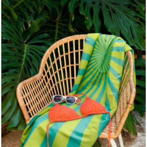 Serviette de plage R-PET posée sur un fauteuil d'extérieur.