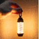 Lampe allumée suspendue par un mousqueton et tenue à la main dans un environnement sombre, laissant apparaître une personnalisat Lampe allumée suspendue par un mousqueton et tenue à la main dans un environnement sombre, laissant apparaître une personnalisat