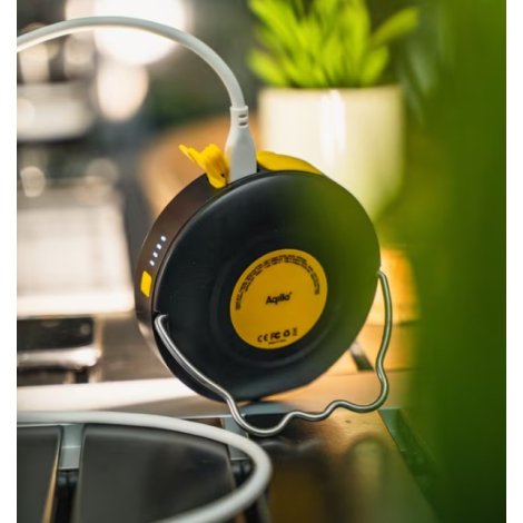 Lampe et batterie externe en cours de recharge sur une table dans un environnement intérieur, avec câble connecté et indicateurs