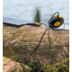 Lampe et batterie externe reliées à un panneau solaire portable, posées sur un tronc d’arbre au bord de l’eau dans un environnem