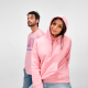 Sweat à capuche pour femme porté de devant, sans personnalisation visible, avec un homme en arrière-plan portant un t-shirt. Sweat à capuche pour femme porté de devant, sans personnalisation visible, avec un homme en arrière-plan portant un t-shirt.