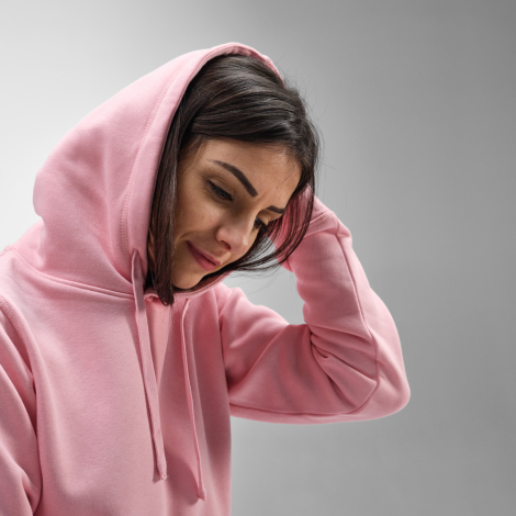 Gros plan sur un sweat à capuche pour femme mettant en évidence la capuche, les cordons ton sur ton et la partie supérieure du v