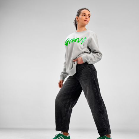 Sweat à col rond unisexe porté par une femme, présenté de trois quarts de devant avec un marquage visible sur le devant.