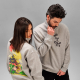 Sweats à col montant avec demi-zip portés par un homme et une femme, avec un marquage visible sur le devant du sweat de l'homme Sweats à col montant avec demi-zip portés par un homme et une femme, avec un marquage visible sur le devant du sweat de l'homme