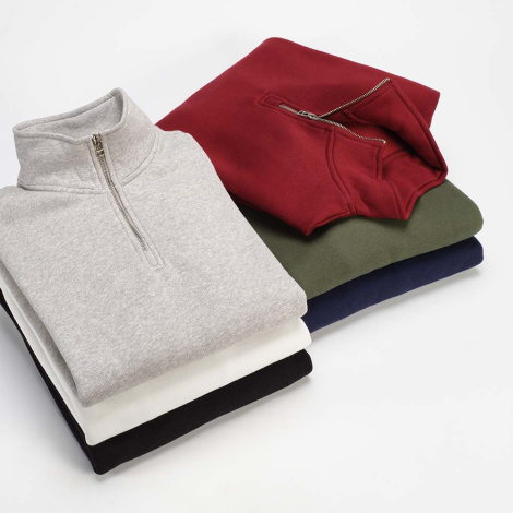 Pile de sweats à col montant avec demi-zip unisexes présentés dans six coloris différents, sans personnalisation visible.