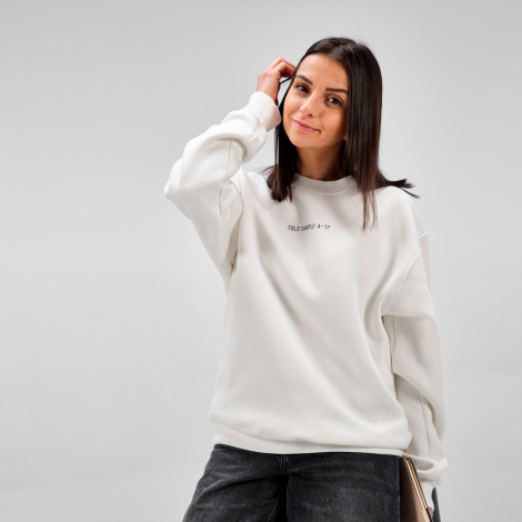 Sweat à col rond porté par une femme, présenté de trois quarts de devant, avec une inscription visible sur le devant.