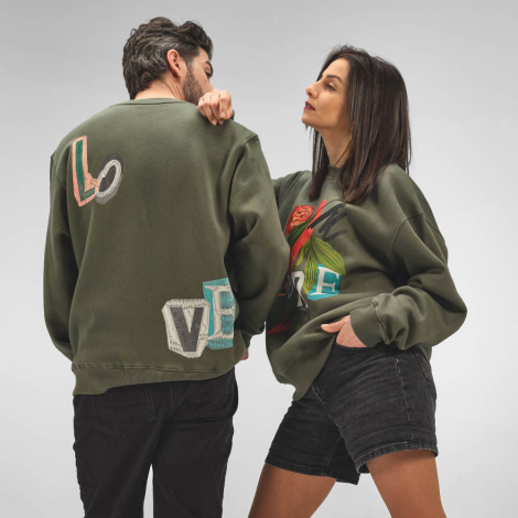 Sweats à col rond portés par un homme et une femme, avec un motif visible sur le devant du sweat de la femme et plusieurs motifs