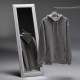 Sweat à capuche unisexe gris suspendu sur un cintre avec son reflet dans un miroir, sans personnalisation visible.