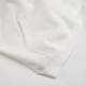 Gros plan sur la poche kangourou et le bord-côte inférieur d'un sweat à capuche blanc, sans personnalisation visible.