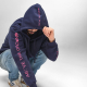 Sweat à capuche porté par un homme, avec des inscriptions visibles sur la manche et la capuche.