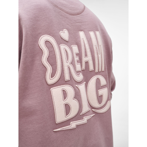Gros plan sur une grande inscription en matière textile appliquée dans le dos d'un sweat.