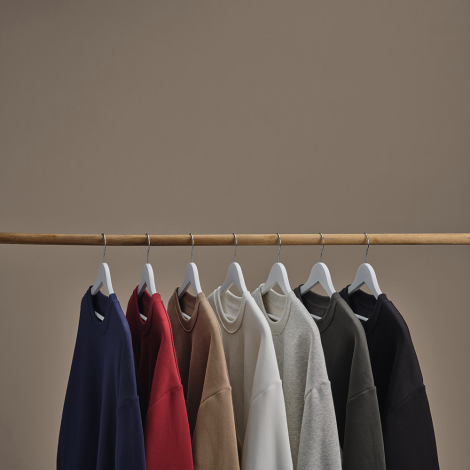 Sweats oversize suspendus dans différents coloris, sans personnalisation visible.