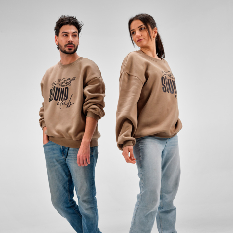 Sweats oversize portés par un homme et une femme, avec un graphisme et une inscription visibles sur le devant.