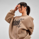 Sweat oversize porté par une femme, avec un graphisme et une inscription visibles sur le devant.