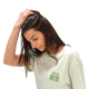 Gros plan sur une femme portant un t-shirt vert clair avec un marquage visible sur le côté gauche de la poitrine. Gros plan sur une femme portant un t-shirt vert clair avec un marquage visible sur le côté gauche de la poitrine.