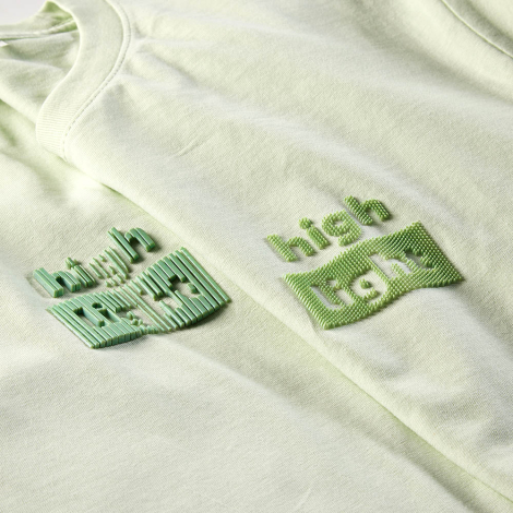 Gros plan comparant deux marquages en relief réalisés sur des t-shirts vert clair.