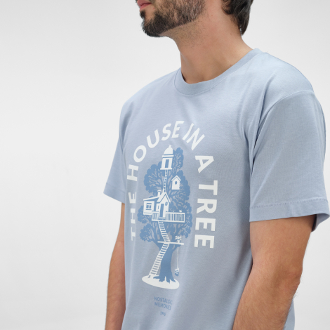 Gros plan sur un homme portant un t-shirt bleu clair avec un marquage visible sur le devant.