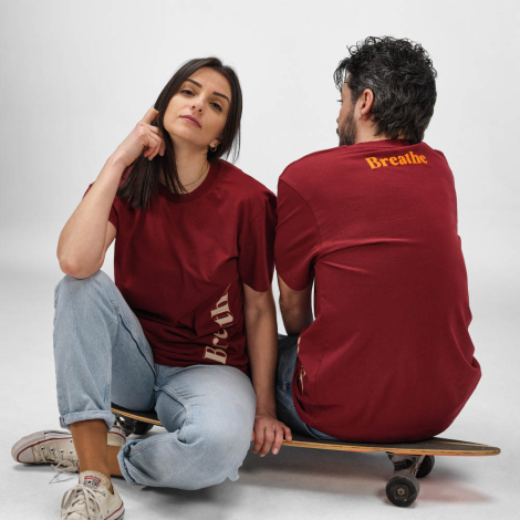 Une femme et un homme portent un t-shirt unisexe avec un marquage visible sur le côté du devant du modèle femme et en haut du do