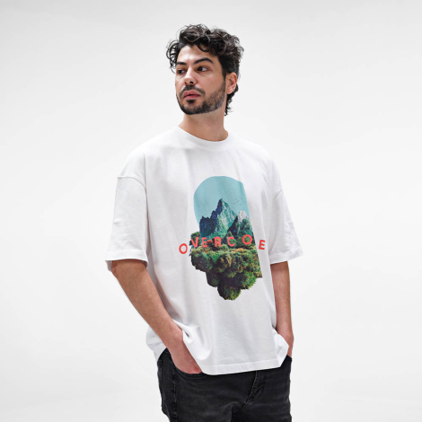 Homme portant un t-shirt oversize blanc avec un marquage visible au centre de la poitrine.
