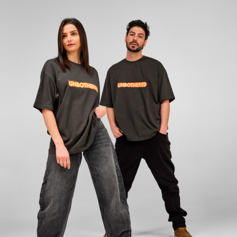 Homme et femme portant un t-shirt oversize foncé avec un marquage visible au centre de la poitrine.