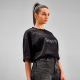 Femme portant un t-shirt oversize noir avec un marquage visible au centre de la poitrine. Femme portant un t-shirt oversize noir avec un marquage visible au centre de la poitrine.