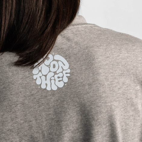 Gros plan sur le haut du dos d'un t-shirt oversize gris avec un marquage visible au niveau de la nuque.