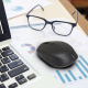 Souris sans fil noire en situation d’utilisation sur un bureau, à proximité d’un ordinateur portable, sans marquage publicitaire Souris sans fil noire en situation d’utilisation sur un bureau, à proximité d’un ordinateur portable, sans marquage publicitaire