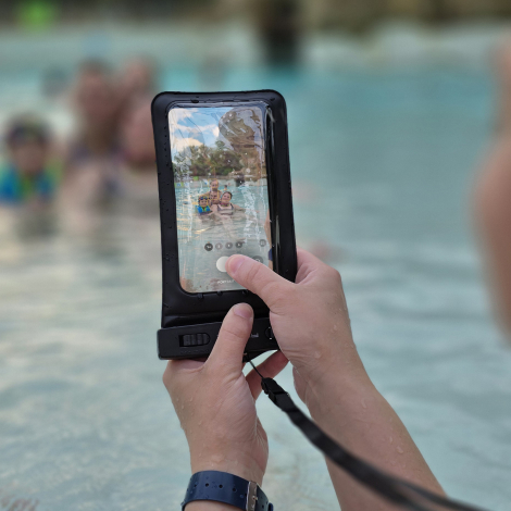 Pochette étanche utilisée à la piscine, permettant de manipuler le smartphone à travers la fenêtre transparente.