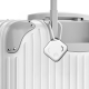 Traceur accroché à une valise grâce à un mousqueton, illustrant son utilisation pour faciliter la localisation des bagages lors Traceur accroché à une valise grâce à un mousqueton, illustrant son utilisation pour faciliter la localisation des bagages lors