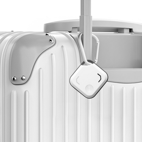 Traceur accroché à une valise grâce à un mousqueton, illustrant son utilisation pour faciliter la localisation des bagages lors 