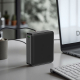 Batterie externe disposée verticalement sur un bureau à proximité d’un ordinateur, avec câble branché sur son port USB-C. Batterie externe disposée verticalement sur un bureau à proximité d’un ordinateur, avec câble branché sur son port USB-C.