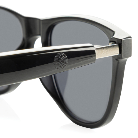 Gros plan sur la branche des lunettes avec un motif visible à proximité de la charnière, sans autre personnalisation apparente.