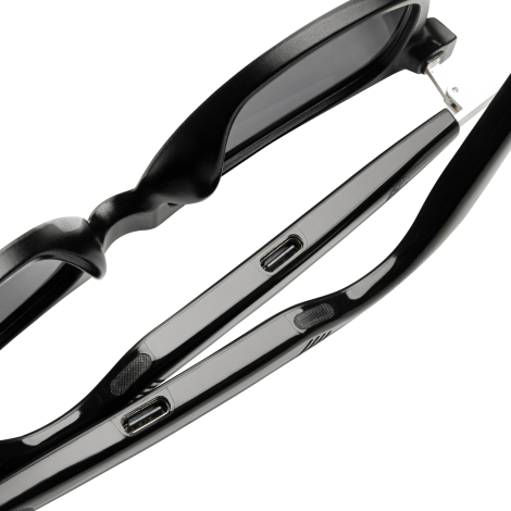 Détail de l'intérieur des branches des lunettes montrant les connecteurs de charge USB-C et les commandes intégrées.