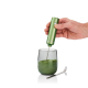 Mousseur électrique vert tenu à la main au-dessus d’un verre contenant une préparation verte en cours de mélange, avec cuillère Mousseur électrique vert tenu à la main au-dessus d’un verre contenant une préparation verte en cours de mélange, avec cuillère