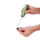 Mousseur électrique vert tenu d’une main, avec tige métallique séparée de son fouet circulaire présenté dans l’autre main. Mousseur électrique vert tenu d’une main, avec tige métallique séparée de son fouet circulaire présenté dans l’autre main.