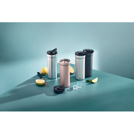 Plusieurs mugs isothermes de différentes finitions disposés sur une surface turquoise avec citrons, glaçons et couvercle amovibl
