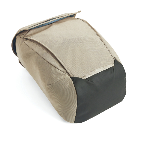 Dessous d’un sac à dos beige vu en détail, avec empiècement inférieur foncé et coutures de renfort.