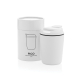 Tasse à café blanche avec couvercle posée devant sa boîte cylindrique assortie, décorée d’un dessin représentant la tasse et de 