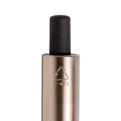 Gros plan sur l’extrémité supérieure d’un stylo à bille, avec bouton-poussoir noir et corps à finition métallique bronze portant