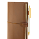 Vue rapprochée du carnet organiseur marron fermé avec un stylo maintenu dans le passant élastique latéral. Vue rapprochée du carnet organiseur marron fermé avec un stylo maintenu dans le passant élastique latéral.