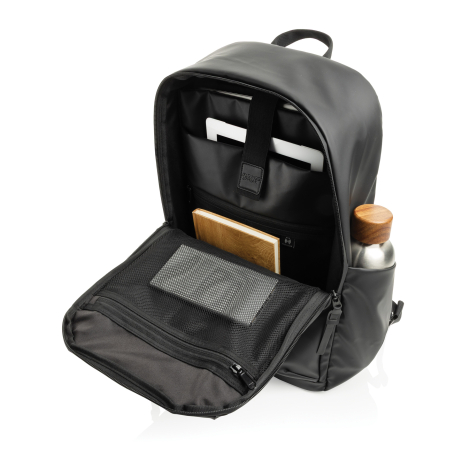 Vue du sac à dos noir ouvert et équipé, avec ordinateur, carnet et autres accessoires rangés dans les différents compartiments, 