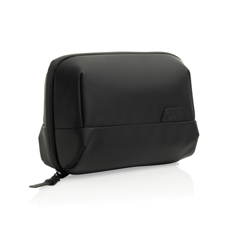 Vue de trois quarts d’une trousse de toilette noire fermée, avec surface supérieure lisse, poche frontale et fermeture zippée su
