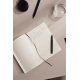 Carnet de notes ouvert sur des pages lignées avec des notes manuscrites, accompagné d’un stylo noir et d’un verre d’eau sur une Carnet de notes ouvert sur des pages lignées avec des notes manuscrites, accompagné d’un stylo noir et d’un verre d’eau sur une