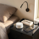 Enceinte à bruit blanc blanche posée sur une table de chevet avec un smartphone, un verre d’eau, un livre et des lunettes, dans Enceinte à bruit blanc blanche posée sur une table de chevet avec un smartphone, un verre d’eau, un livre et des lunettes, dans