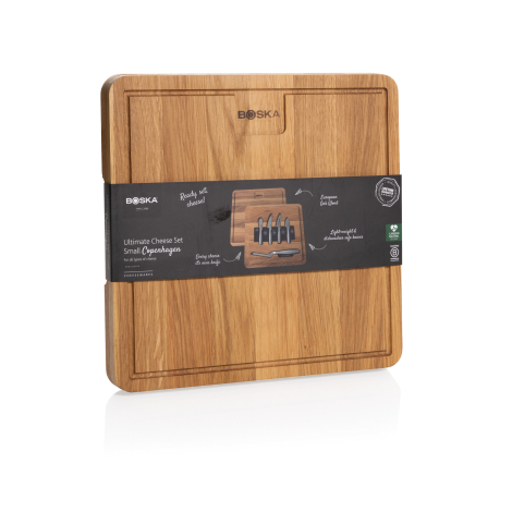 Set à fromage fermé présenté de face, avec grande planche carrée en bois à rainure périphérique et bandeau d’emballage noir auto
