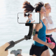 Perche à selfie noire tenue à la main et déployée avec un smartphone en position horizontale, dans une scène de course à pied. A Perche à selfie noire tenue à la main et déployée avec un smartphone en position horizontale, dans une scène de course à pied. A