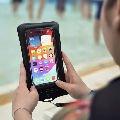 Smartphone utilisé à travers la fenêtre transparente de l’étui étanche.