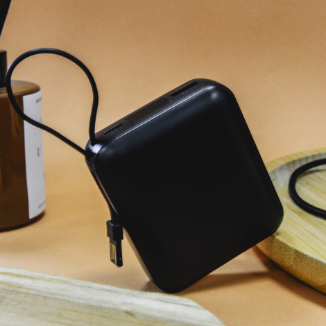 Batterie de secours noire présentée en situation, posée verticalement avec sa dragonne et un connecteur intégré visible. Aucun m