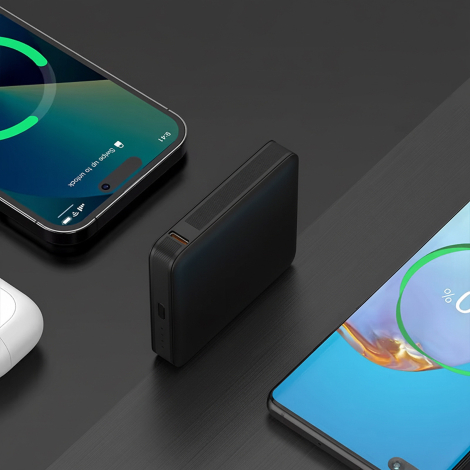 Batterie de secours noire présentée de profil entre plusieurs appareils électroniques. Un port USB-C et des voyants lumineux son